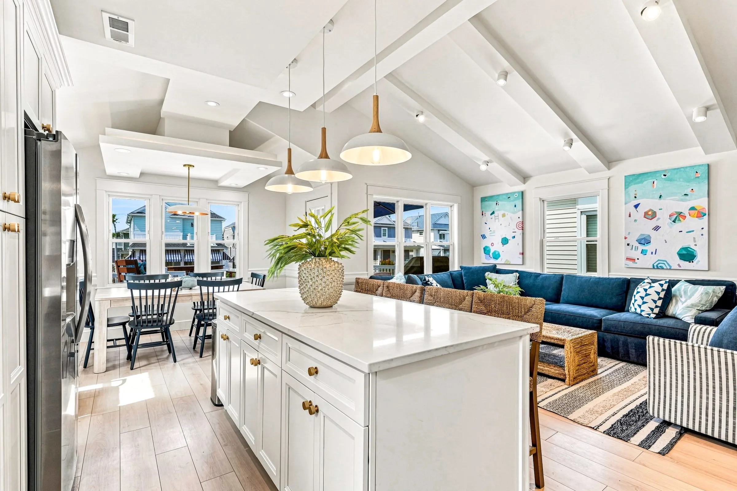 Great room from the kitchen: island, dining table, and living room under one vaulted ceiling