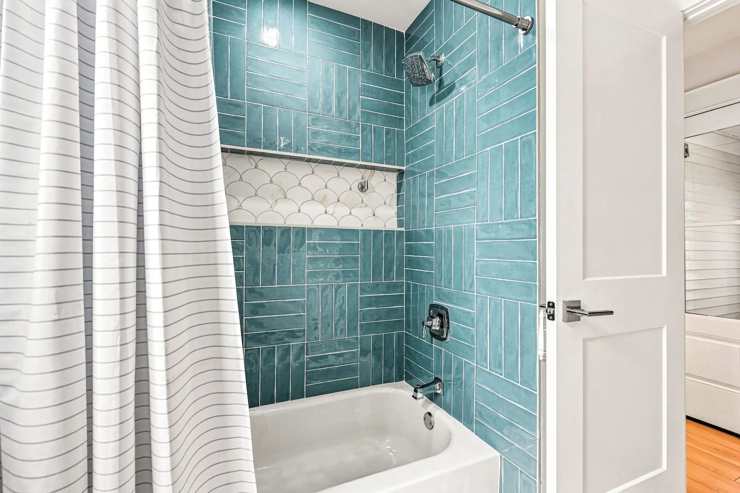 Hall bathroom with a teal-tiled tub and shower
