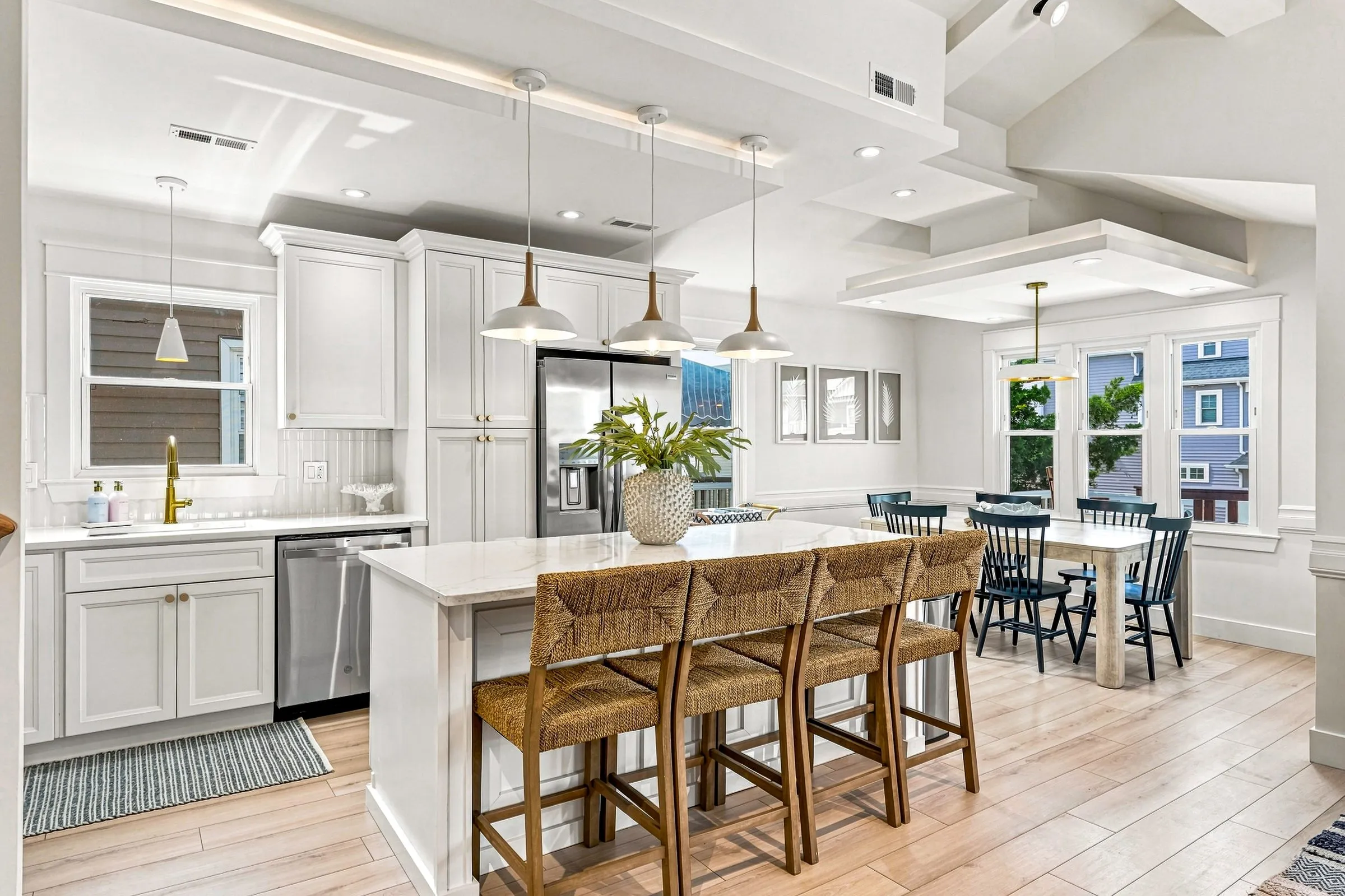 Kitchen with white cabinets, stainless appliances, and the dining table beyond
