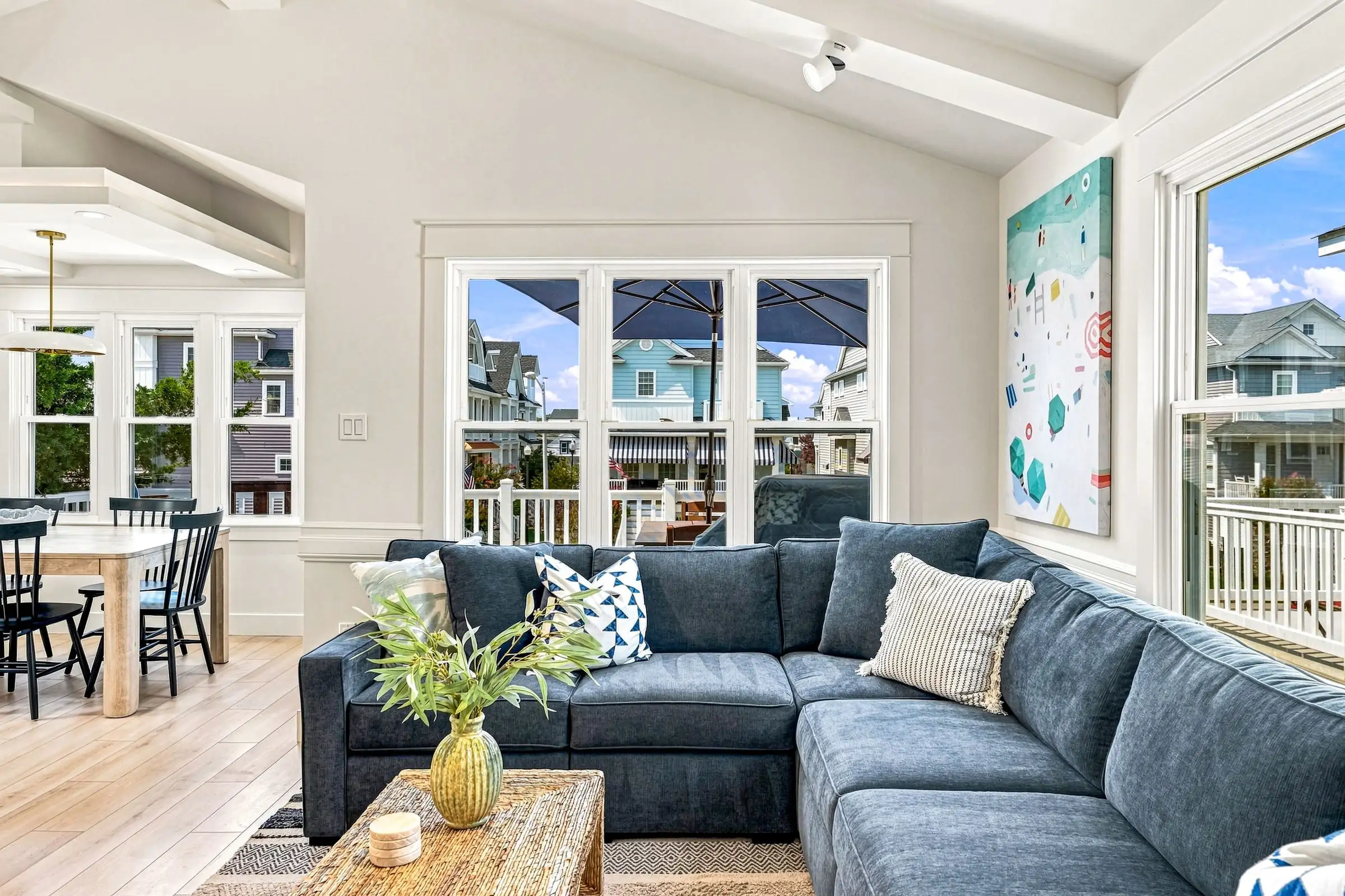 Living room looking toward the deck windows, navy sectional and beach art